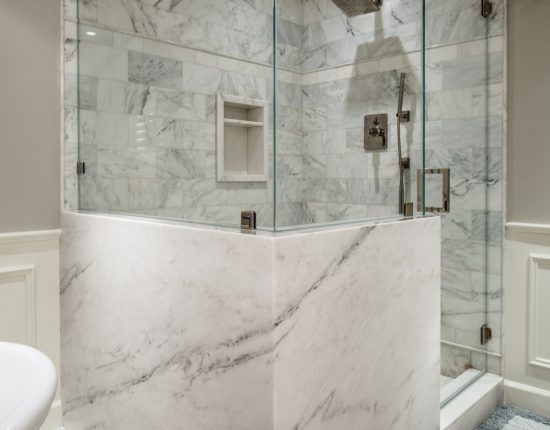 A stone wrapped and frameless glass shower enclosure