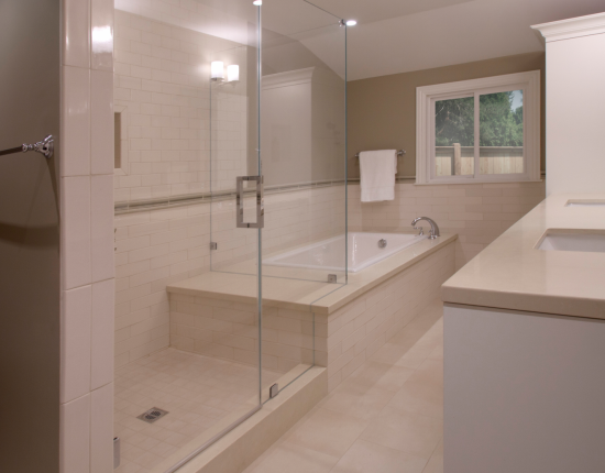 A large frameless glass shower and soaking tub