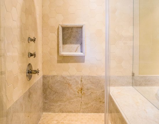 A Frameless Glass Shower With Full Bench And Rain Shower Head-