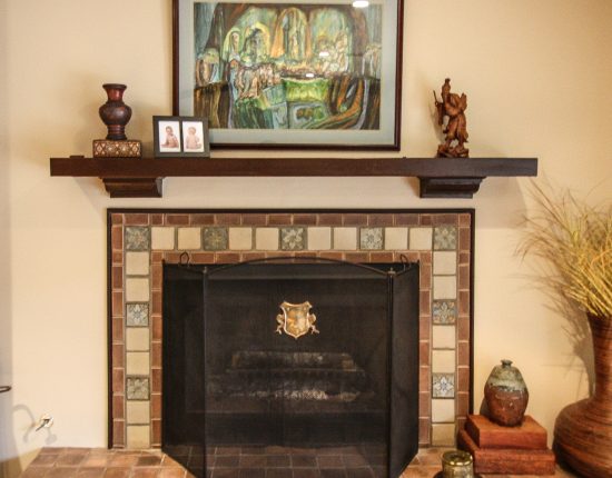 Fireplace With Custom Tile Work And Wood Mantle