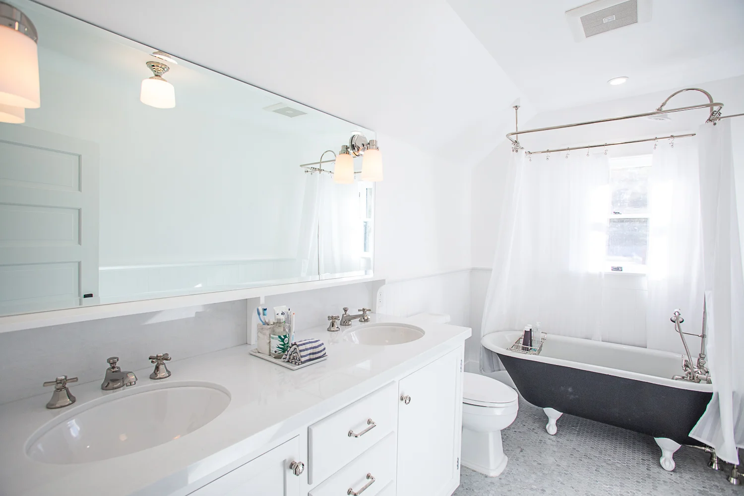 White double vanity bathroom with tiled floors.