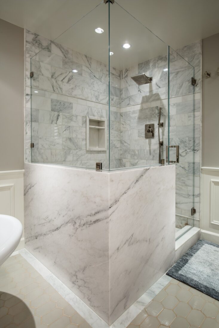A stone wrapped and frameless glass shower enclosure