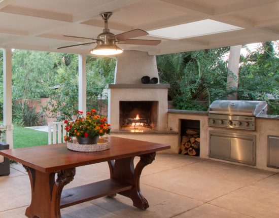 Outdoor entertainment area with wood burning fireplace, BBQ and stone countertops