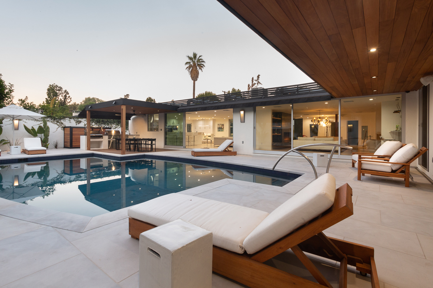 Outdoor living space with lounge seating, dining table, and full outdoor kitchen and BBQ