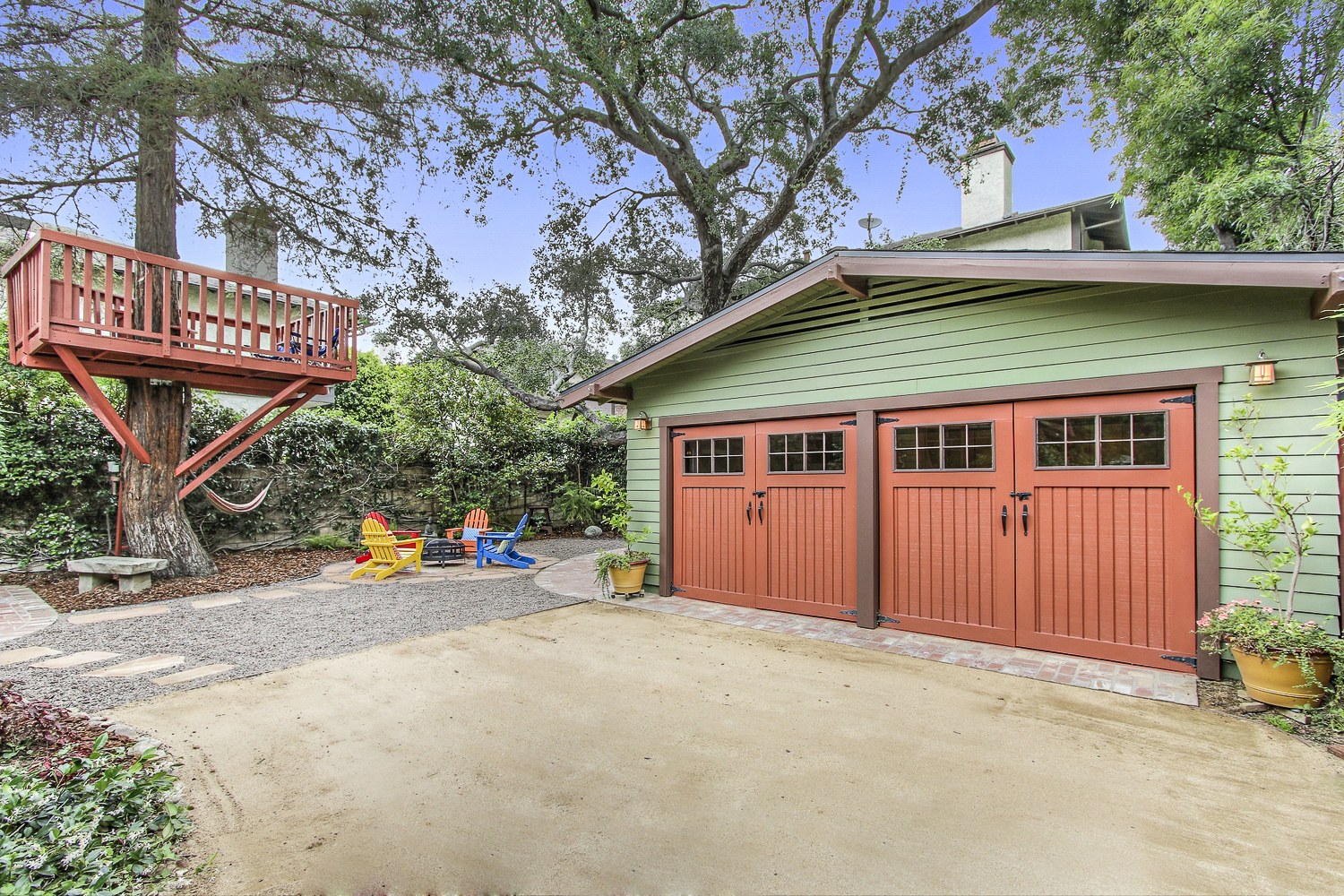 Remodeled backyard designed for outdoor living with treehouse and firepit