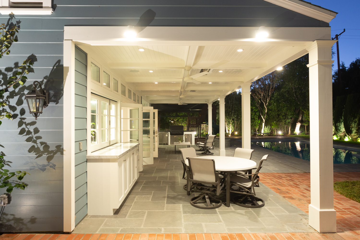 Pool house with outdoor living space including seating, TV and Outdoor Kitchen