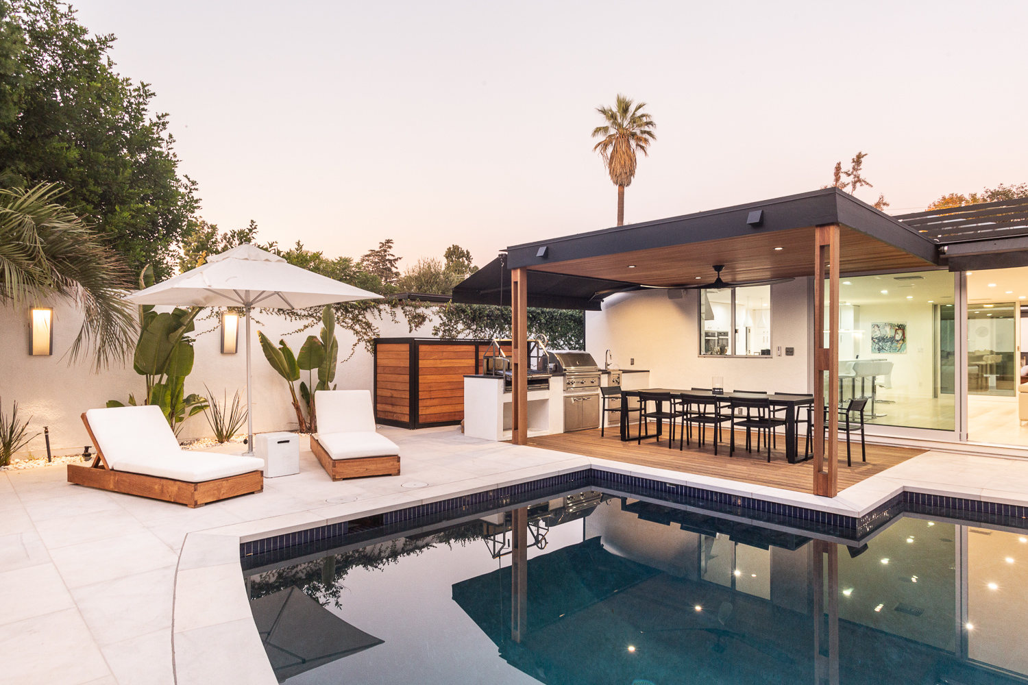 Outdoor living space with lounge seating, dining table, and full outdoor kitchen and BBQ