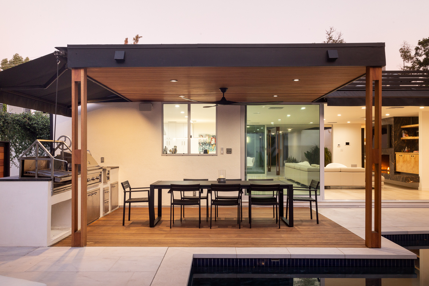 Outdoor living space with lounge seating, dining table, and full outdoor kitchen and BBQ