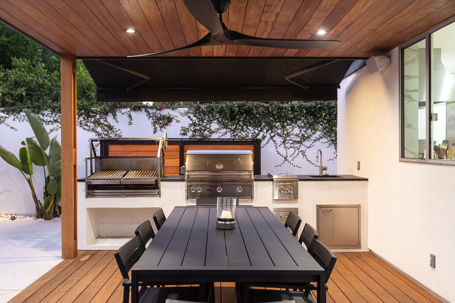 Outdoor living space with lounge seating, dining table, and full outdoor kitchen and BBQ