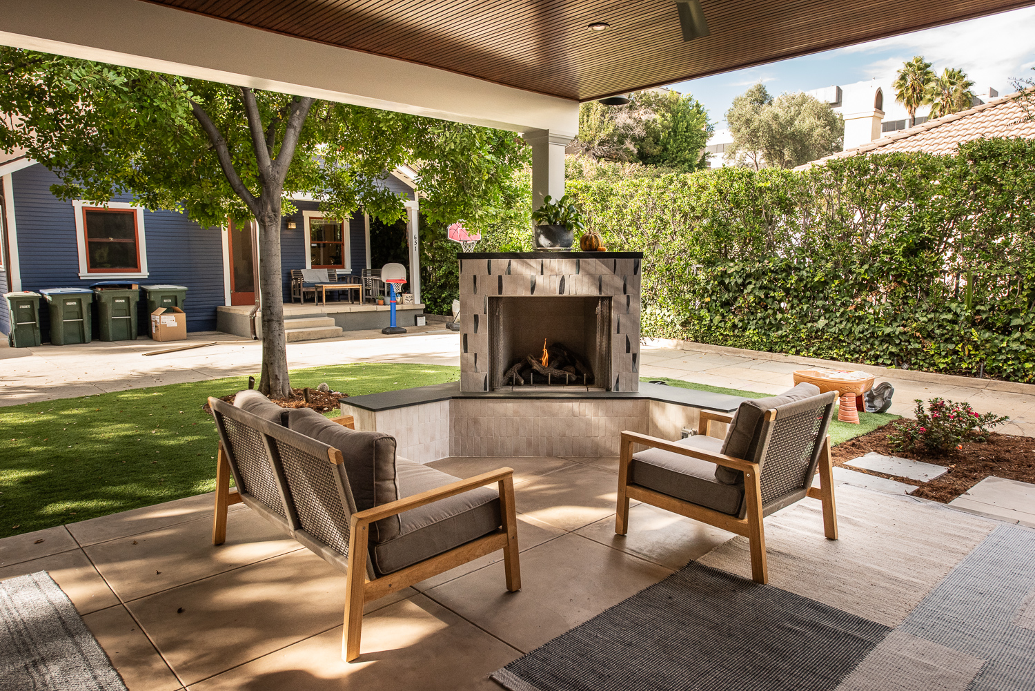Outdoor living space with dining area, fireplace, and outdoor kitchen