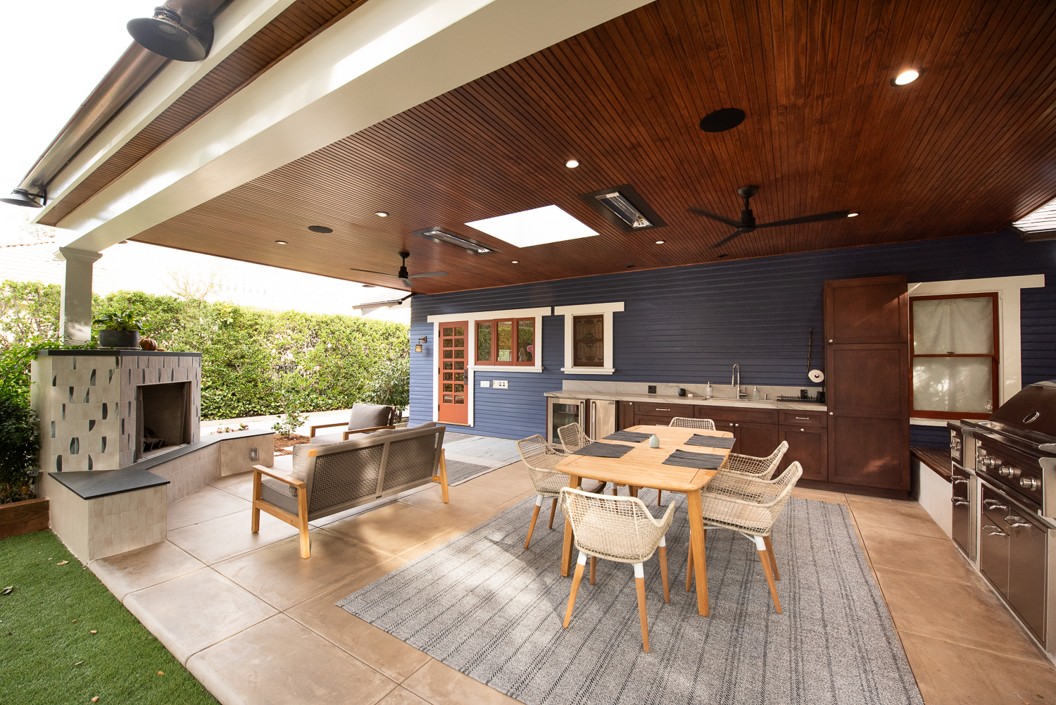 Outdoor living space with dining area, fireplace, and outdoor kitchen