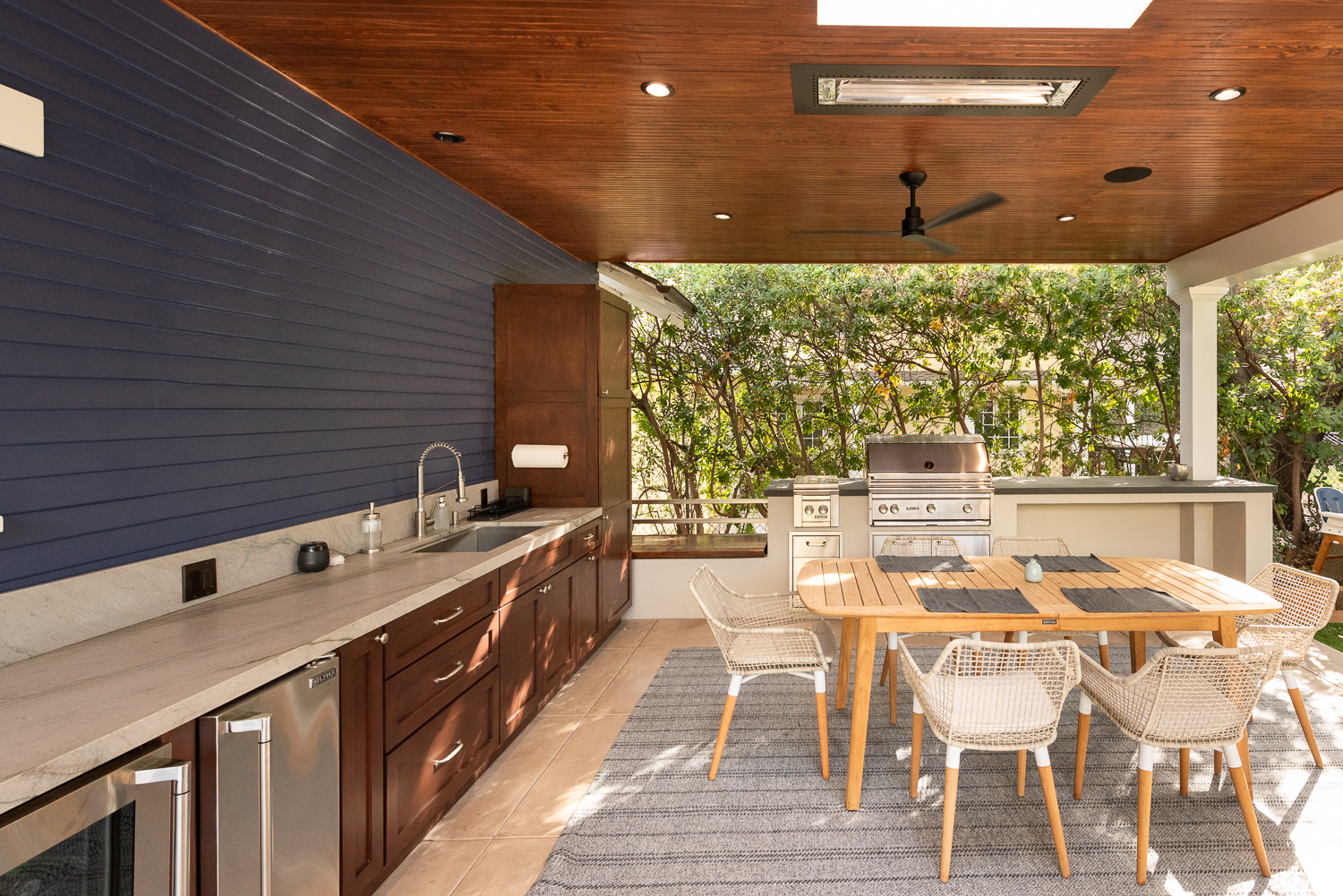 Outdoor living space with dining area, fireplace, and outdoor kitchen