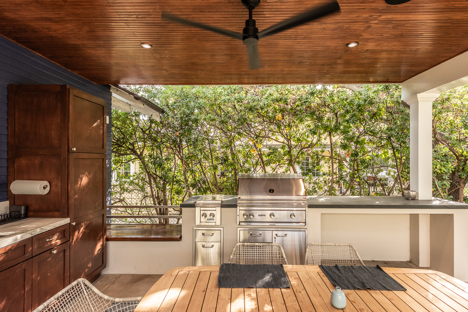Outdoor living space with dining area, fireplace, and outdoor kitchen