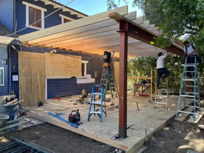 Construction Crew Mounting Wood Beams to Build a Pergola-Covered Patio for a Custom Craftsman Home