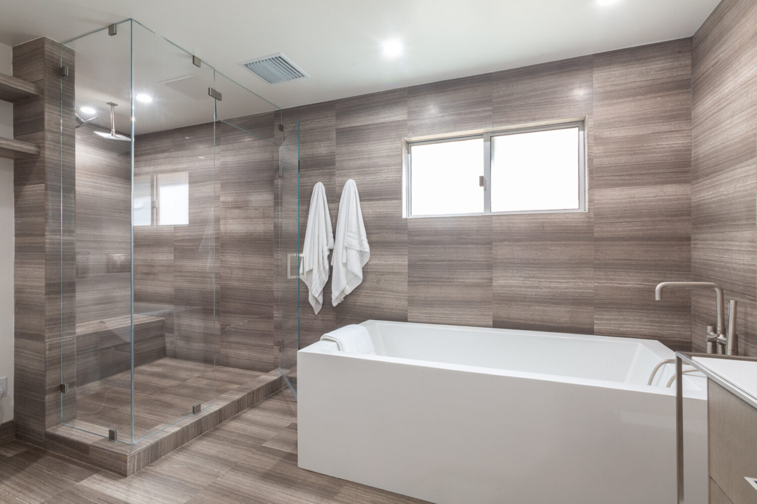 Modern bathroom remodel with sandstone slab design.