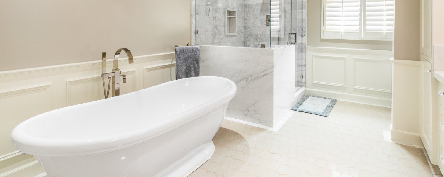 Deep, luxurious bath tub with marble enclosed shower.