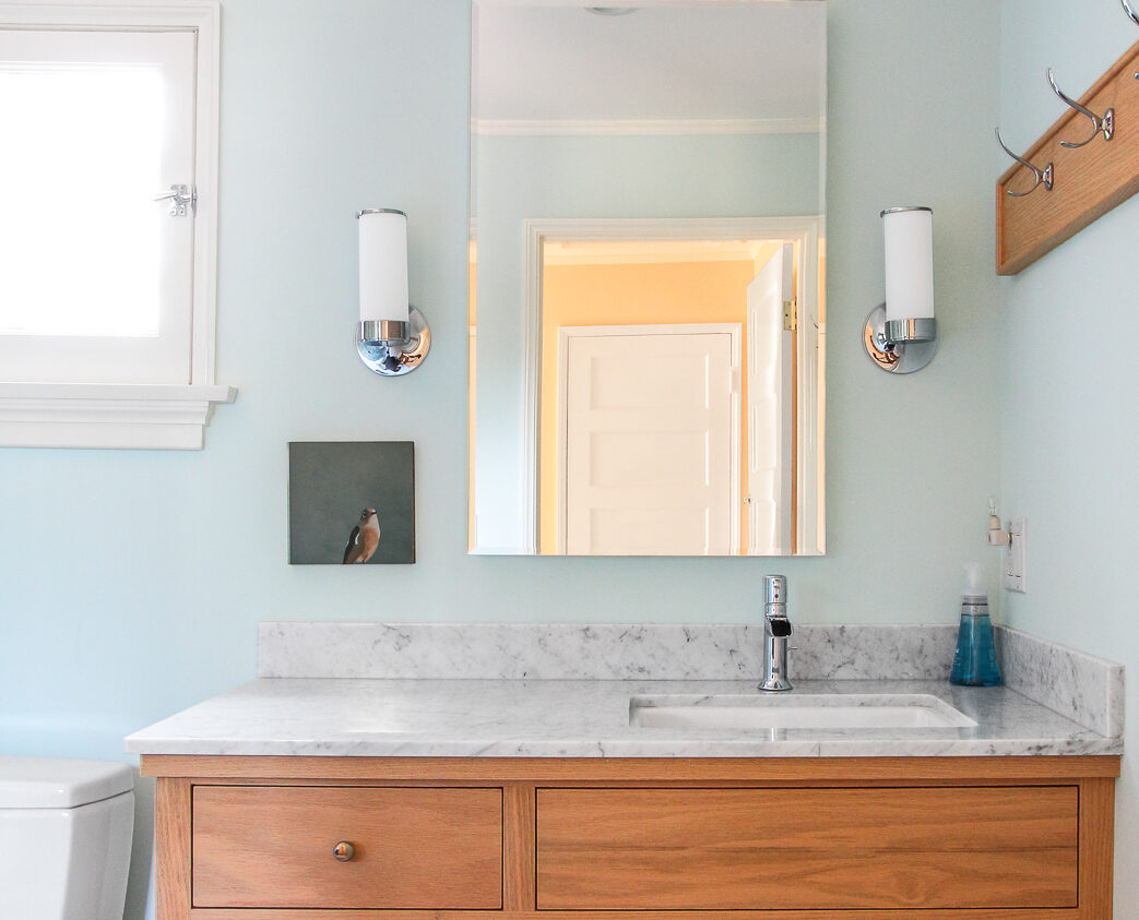 San Marino bathroom remodel, featuring granite counter-top, light blue walls, and elegant mirror and light fixtures.
