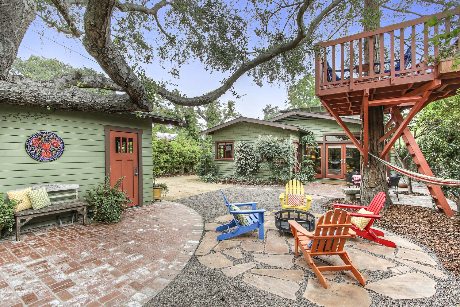 Remodeled backyard designed for outdoor living with treehouse and firepit.