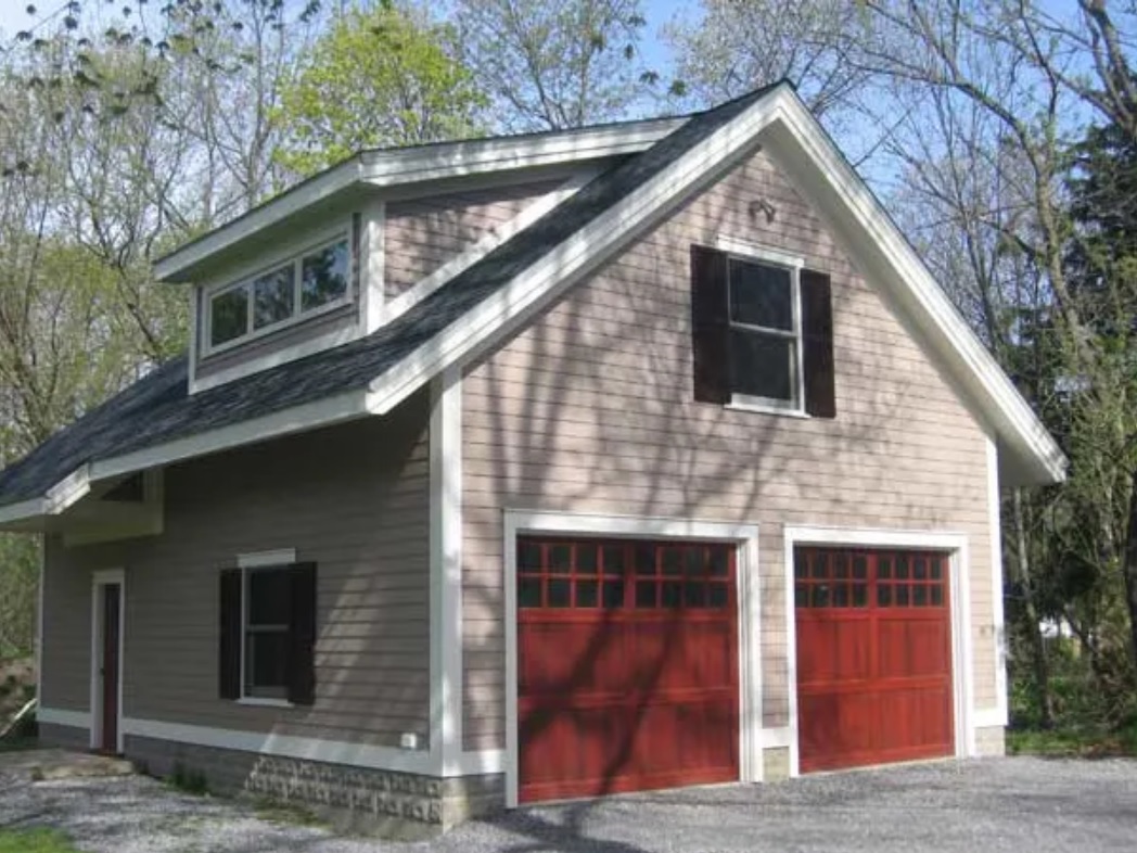 Custom three bay, story-and-a-half garage with red doors.